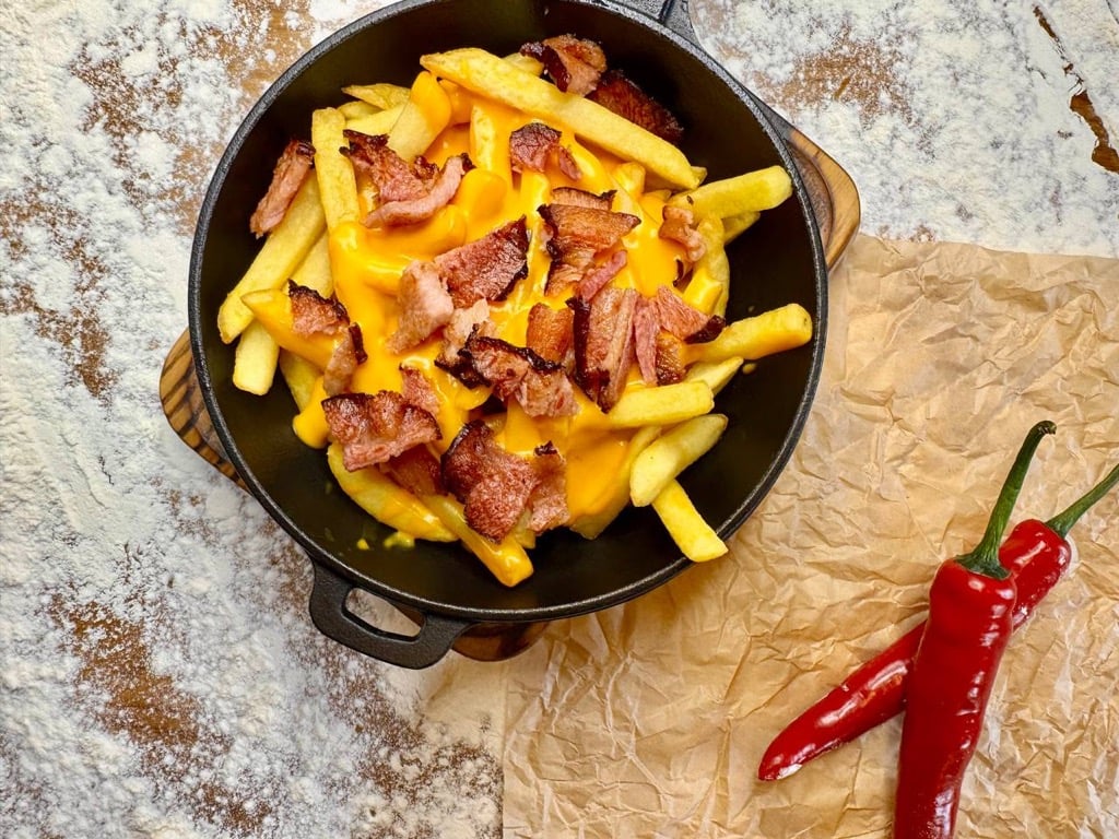 Картопля фрі з сирним соусом і беконом.