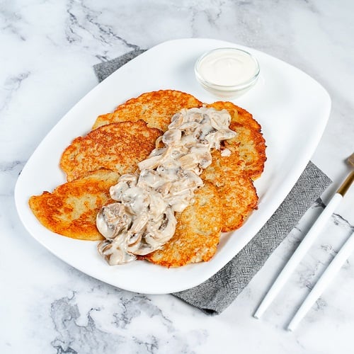 Деруни у грибному соусі з вершками/Potato pancakes under cream sauce with mushrooms 150/60 gm