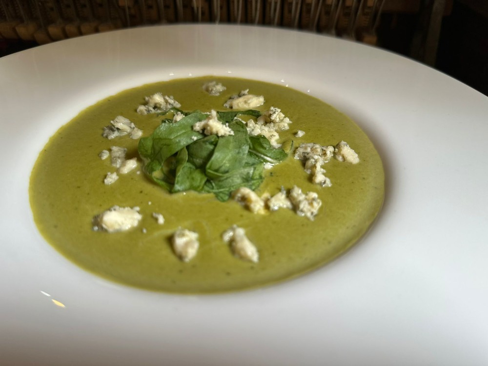 Green pea cream soup with arugula and chicken