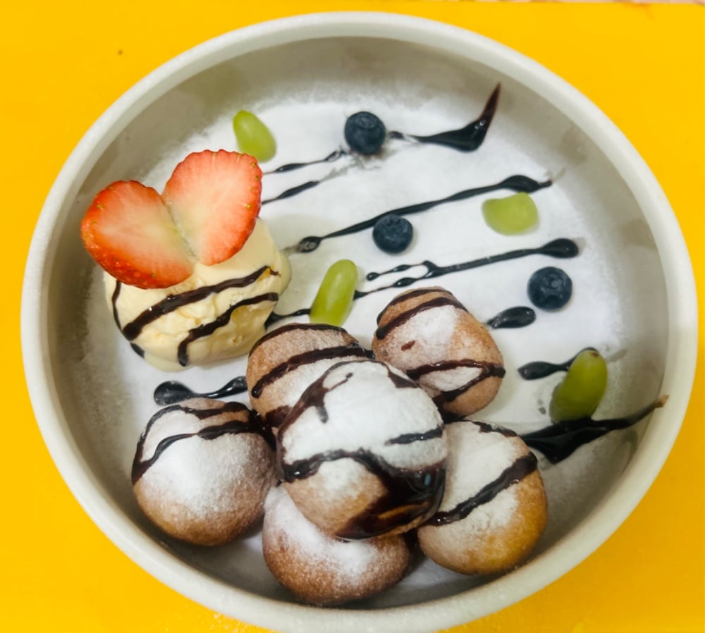 Cottage cheese balls with a scoop of vanilla ice cream with powdered sugar
