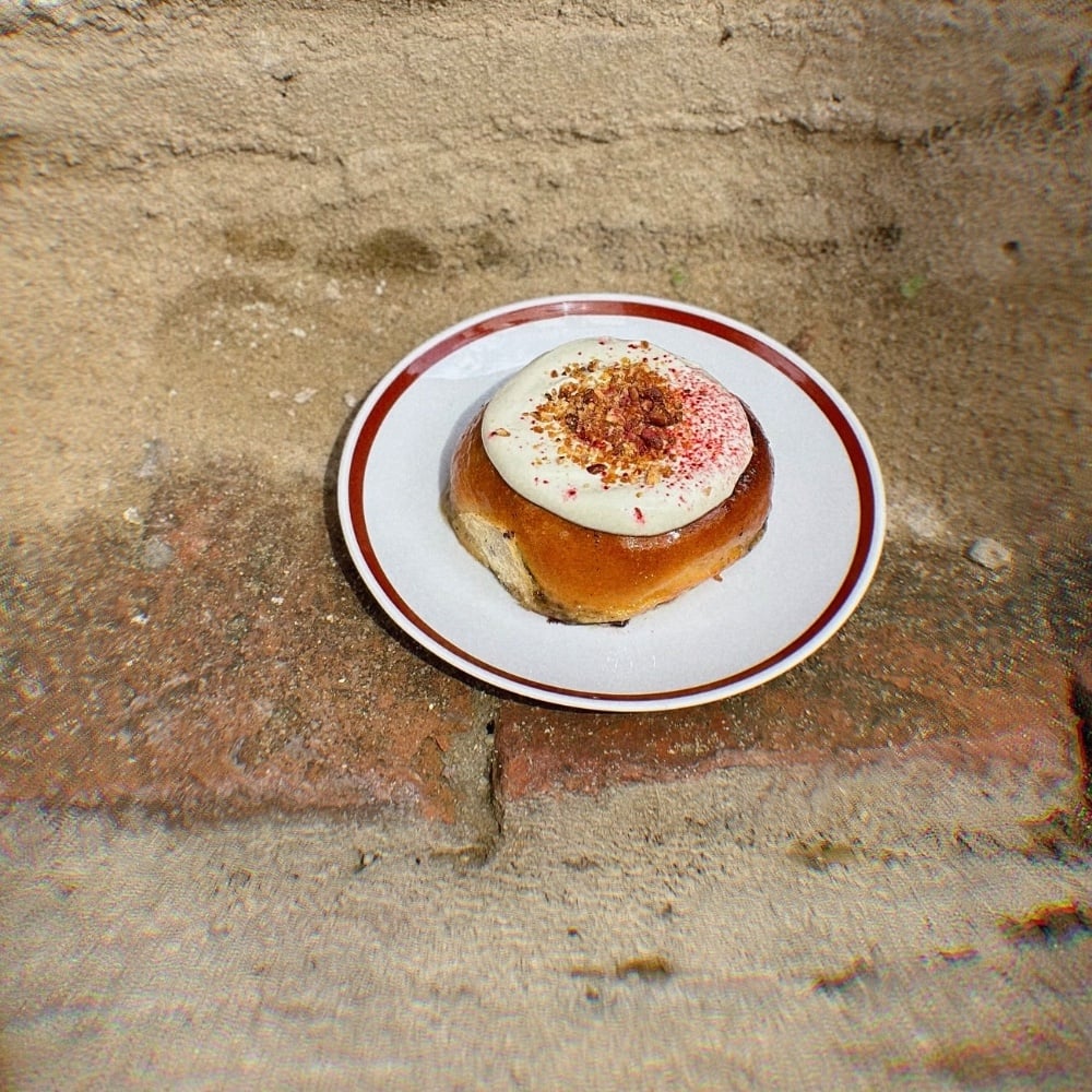 Cinnamon bun w pistachio & black sesame & raspberries