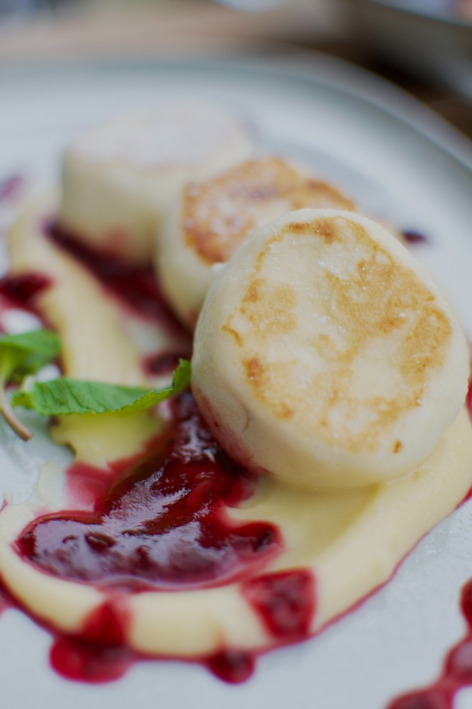 Сирники на подушці заварного крему та ягідним соусом