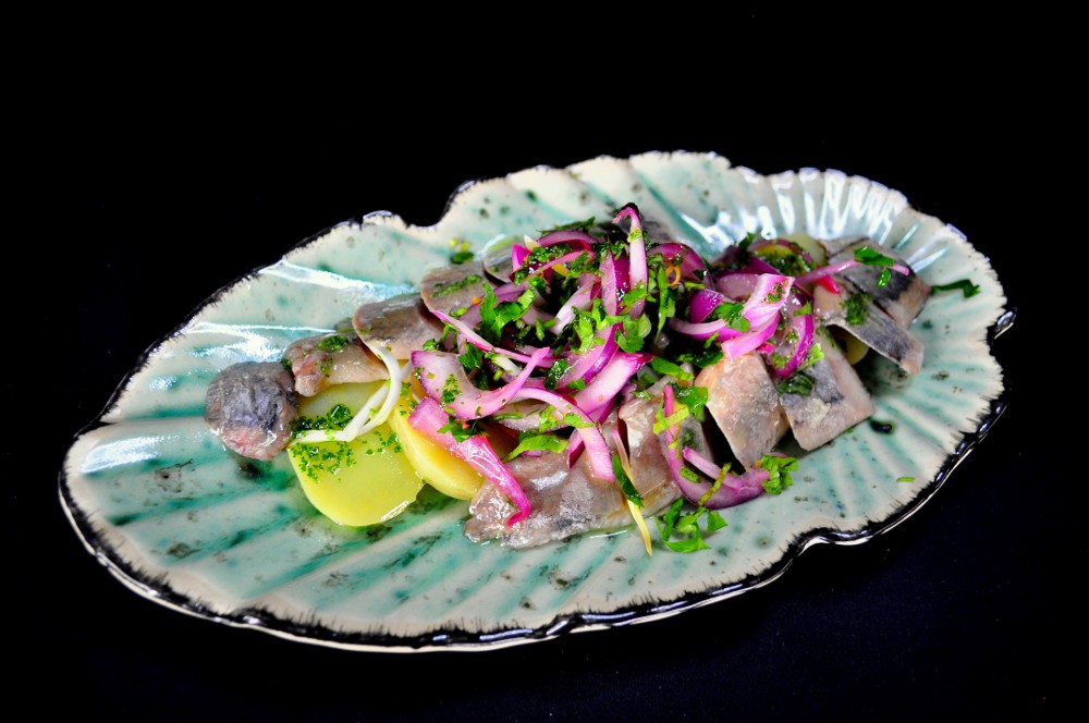 Оселедець на картопляній подушці з маринованою цибулею