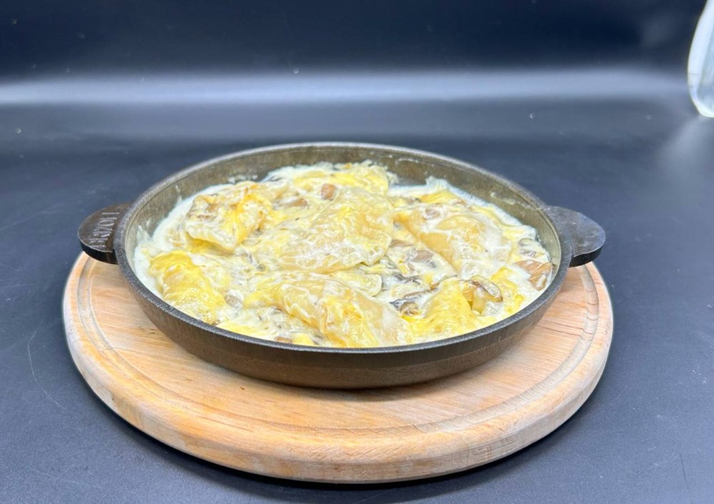 Вареники з картоплею під вершковим соусом з грибами та сиром
