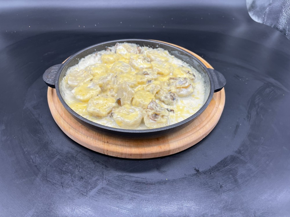 Пельмені під вершковим соусом з сиром та грибами