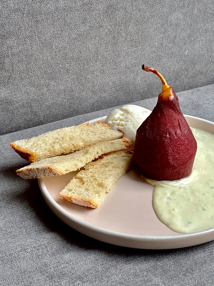 Груша, томлена у пряному вині з соусом дор блю, кулькою пломбіру і грінками