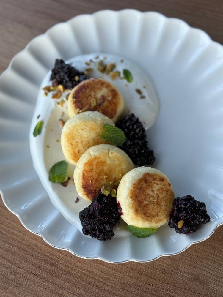 Сирники із сметанним кремом та ягідним соусом