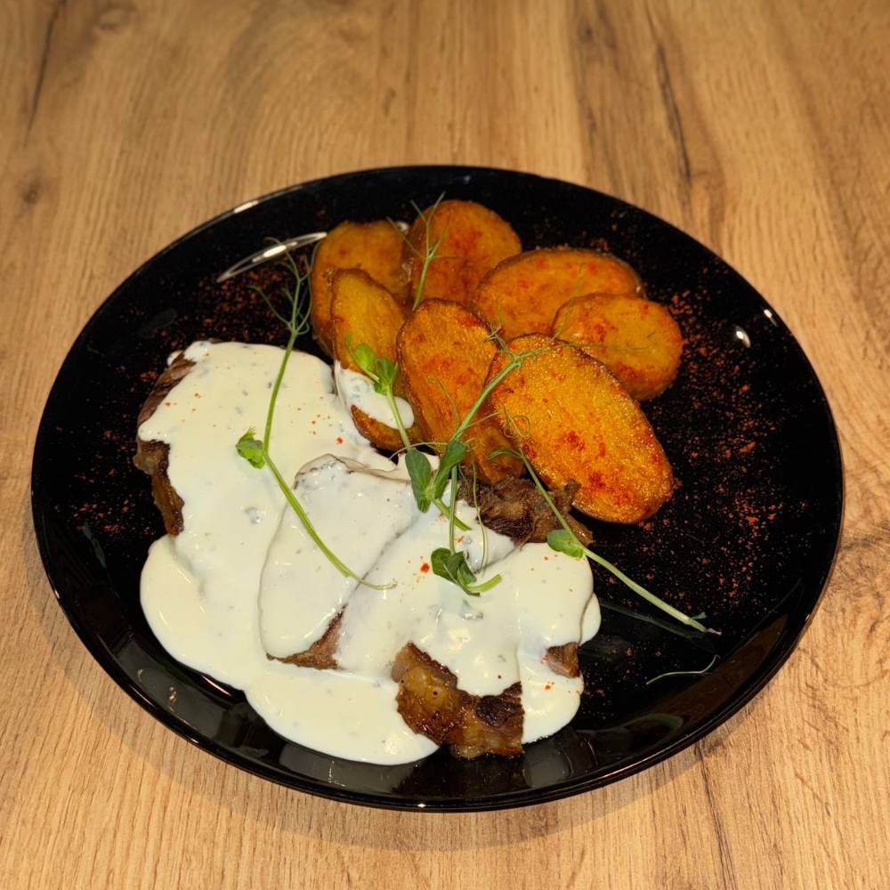 Стейк зі свинини під соусом Дор-Блю з картоплею по-креольськи