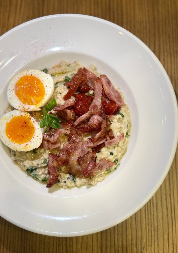 Цільнозернова вівсяна каша з беконом, пармезаном, шпинатом та яйцем