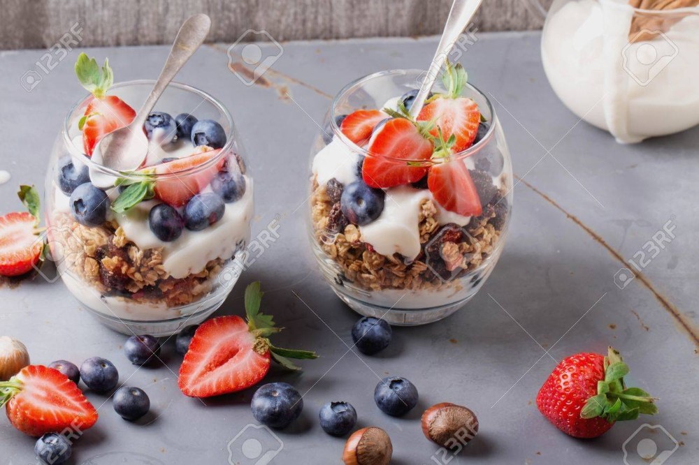 Yogurt con fresas, arándano, miel y granola.